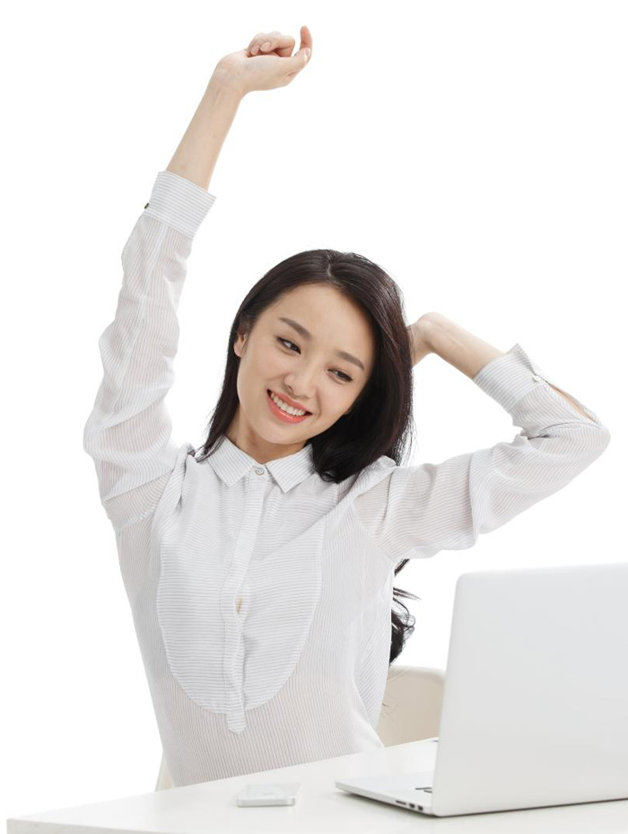 在电脑前伸懒腰放松心情的美女