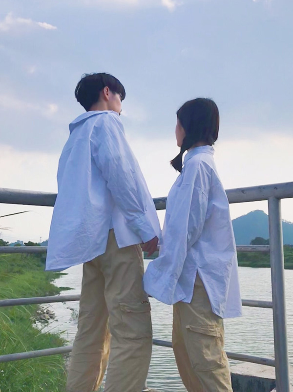 学生情侣牵手在河边看风景