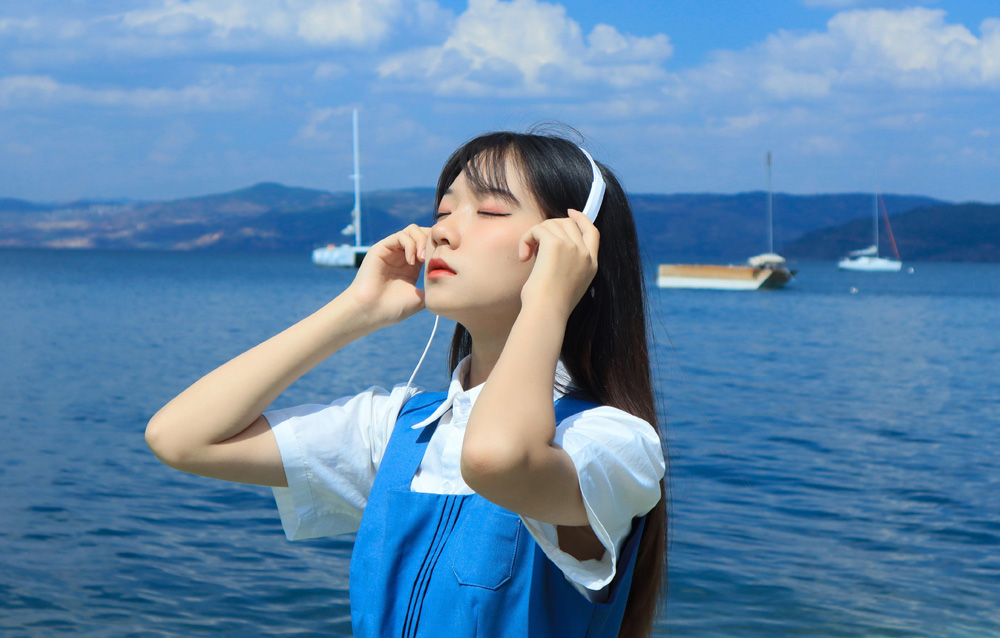 在海边听音乐的小美女