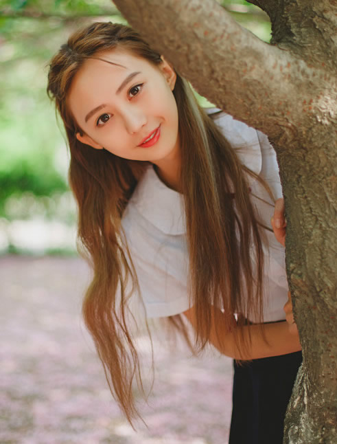 从大树后面钻出来一个小美女