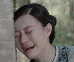 头靠在墙上伤心痛哭的女人
